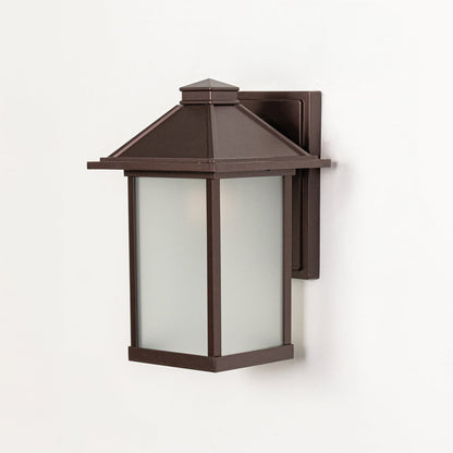 Brown metal wall mounted outdoor lantern switched off on white background emphasizing clean structure and frosted glass panels.