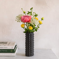 Dark grey textured ceramic floor vase with geometric carved pattern styled as modern accent decor for living room interiors.
