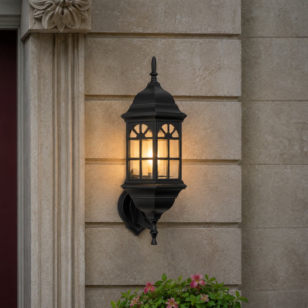 Black metal outdoor wall light lifestyle image with arched paneled glass shade mounted on an elegant stone column.