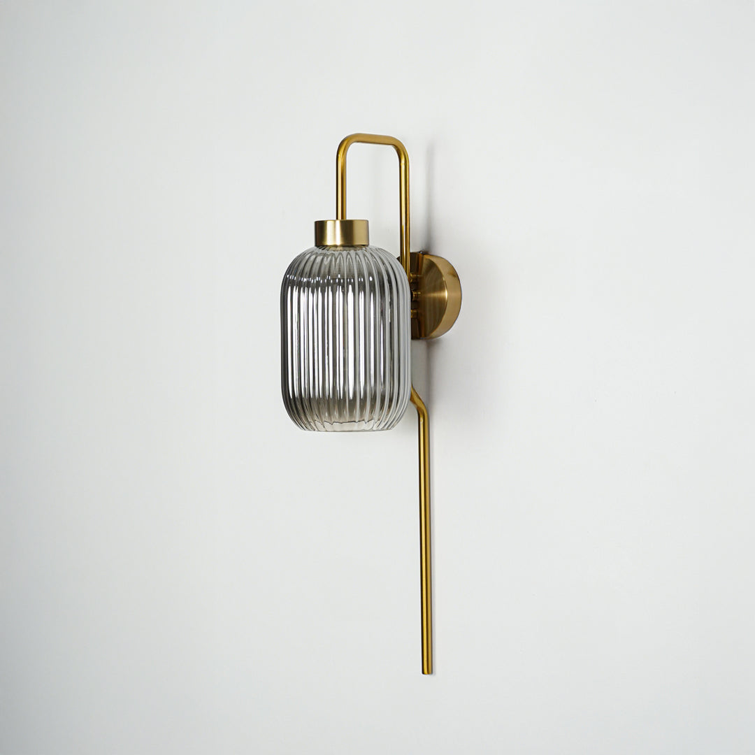 Gold finish wall light with smoked ribbed glass shade perfect for elegant interior wall decor placement on clean background.