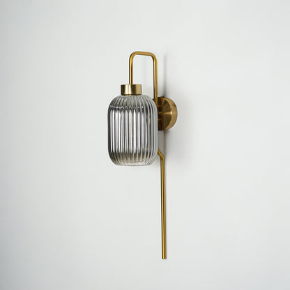 Gold finish wall light with smoked ribbed glass shade perfect for elegant interior wall decor placement on clean background.