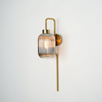 Gold metal wall light with ribbed glass shade and vertical rod design ideal for modern bedroom or hallway wall decor.