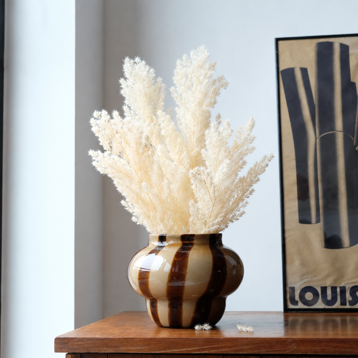 Lifestyle image of white dried fern asparagus for elegant home interior decor styling and modern room tabletop decoration.