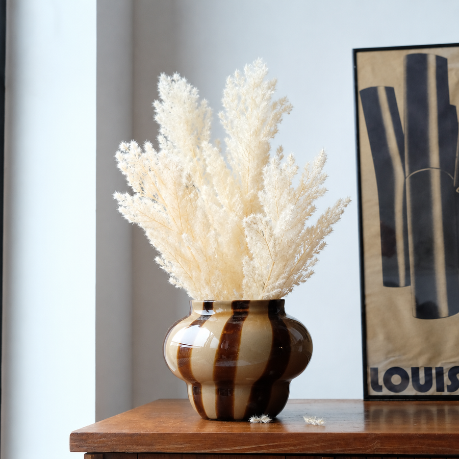Lifestyle image of white dried fern asparagus for elegant home interior decor styling and modern room tabletop decoration.