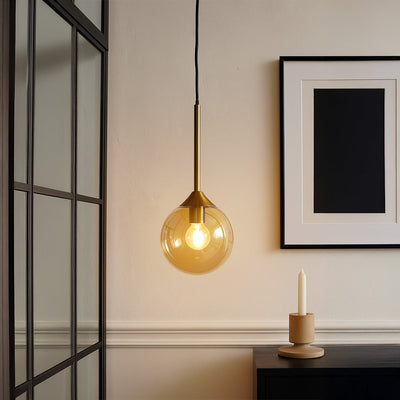 Amber glass pendant light illuminating reading corner with warm contemporary sophistication indoors.
