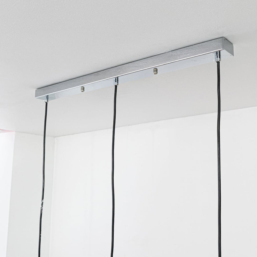 Silver metal linear canopy with suspended cords highlighting sleek modern craftsmanship and finish.