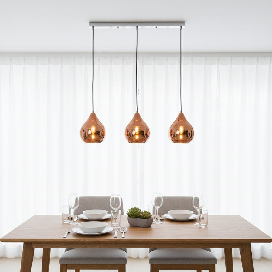 Amber glass pendant lights creating warm ambience above the dining table in modern interiors.