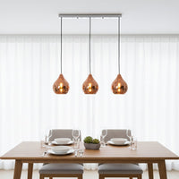 Amber glass pendant lights creating warm ambience above the dining table in modern interiors.