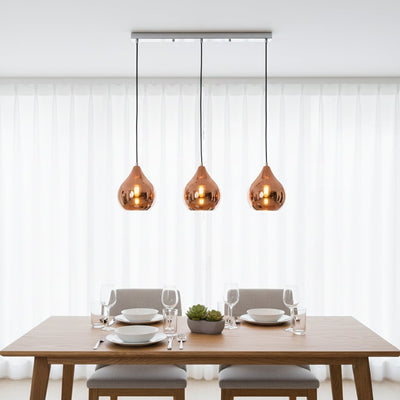 Amber glass pendant lights creating warm ambience above the dining table in modern interiors.