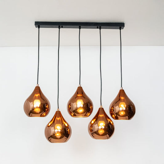 Warm glowing copper teardrop pendant cluster with five sculpted shades displayed on a bright white background for stylish decor inspiration.