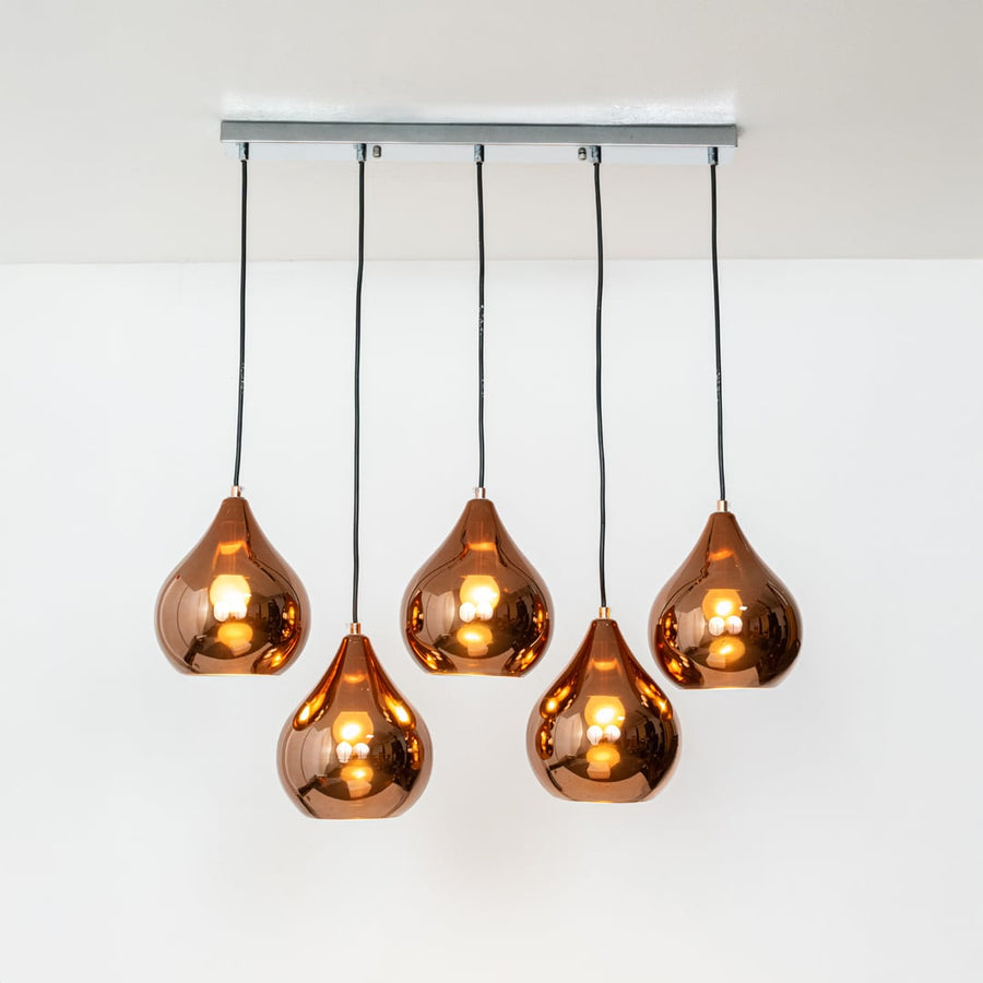 Warm glowing copper teardrop pendant cluster with five sculpted shades displayed on a bright white background for stylish modern decor inspiration.