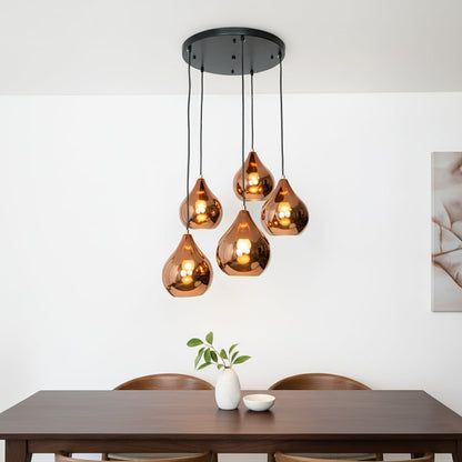 Amber metallic glass pendant lights creating warm ambience above the dining table in modern interiors.