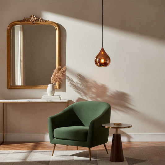 Copper metal pendant light with teardrop shape styled in modern interior creating warm reflective ceiling lighting ambiance.