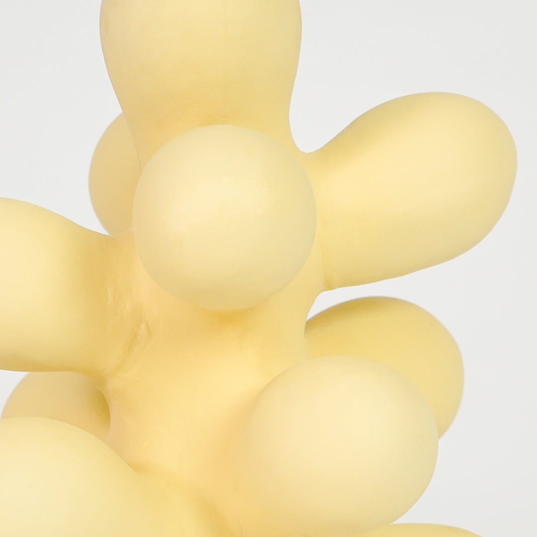 Closeup image of beige resin abstract decor sculpture for modern shelf styling with smooth matte artistic finish.
