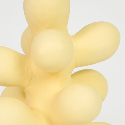 Closeup image of beige resin abstract decor sculpture for modern shelf styling with smooth matte artistic finish.
