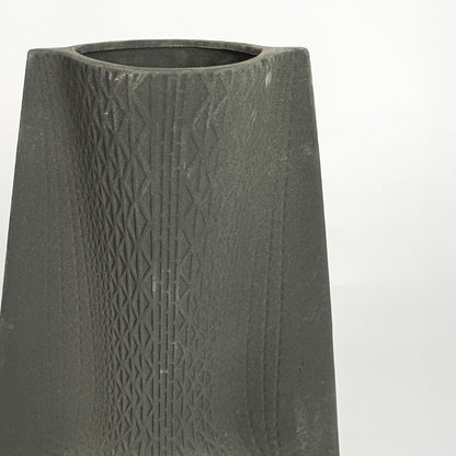 Close up view black textured ceramic vase showing carved surface matte finish decorative ceramic accent for modern home styling.