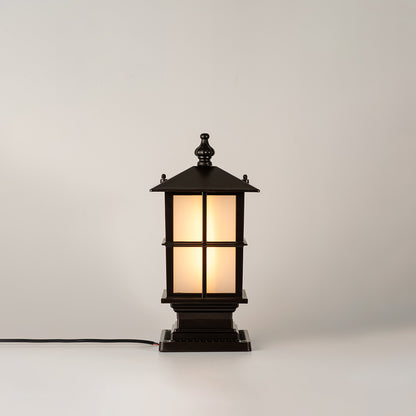 Vintage black outdoor gate light with warm glowing glass panels for elegant exterior decor use.