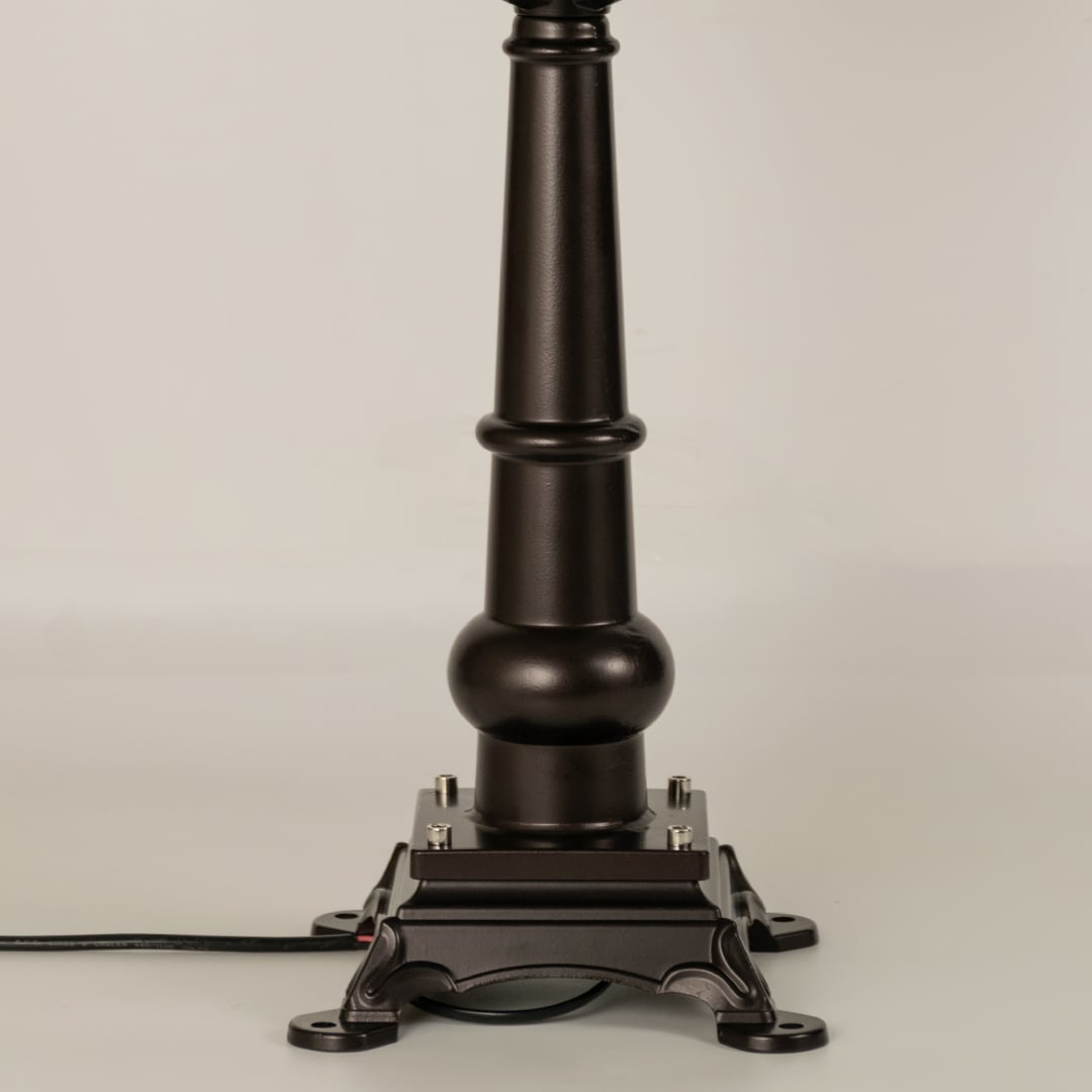 Closeup of black outdoor gate light base with elegant metal detailing for luxury exterior decor use.