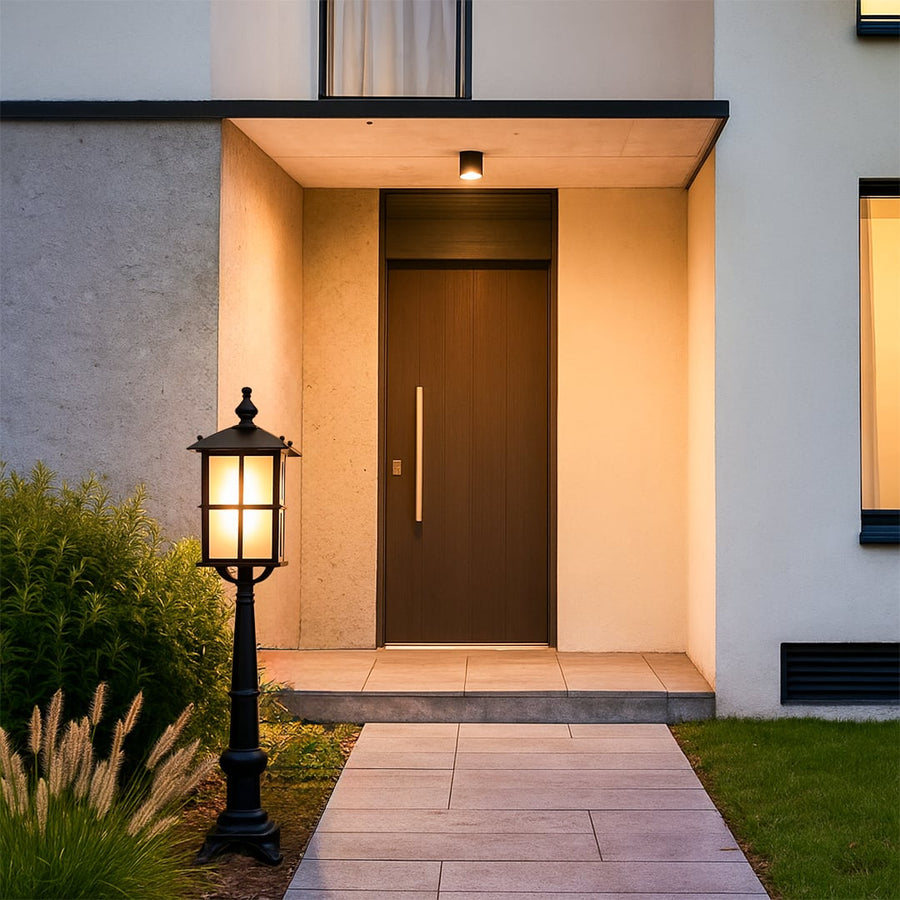 Vintage black outdoor gate light styled beside pathway for elegant modern exterior decor ambiance.