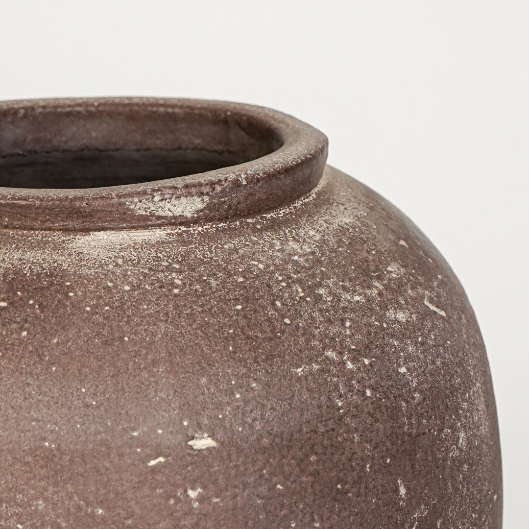 Closeup image of brown ceramic floor vase for rustic living room decor styling with textured matte finish.