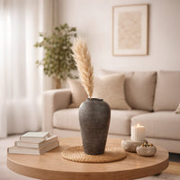 Black textured decorative vase lifestyle image on wooden table for elegant modern living room decor.
