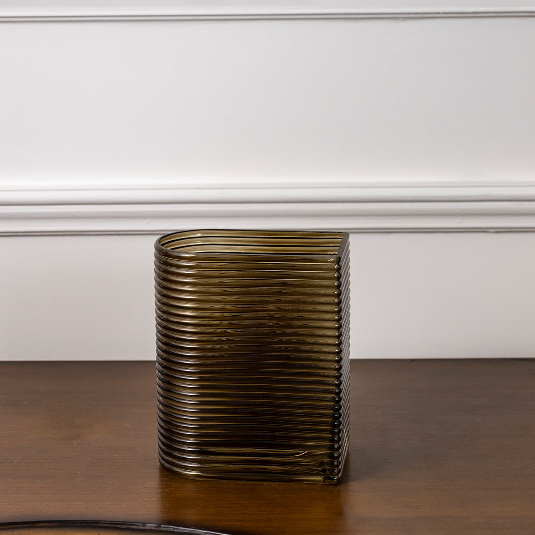 Amber ribbed glass decorative vase styled on a wooden table for elegant contemporary home decor arrangements.