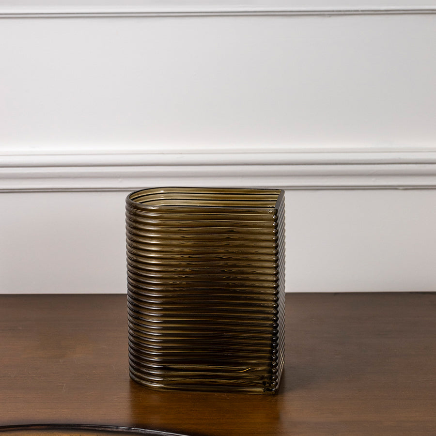 Amber ribbed glass decorative vase styled on a wooden table for elegant contemporary home decor arrangements.