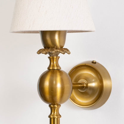 Detailed macro view of a vintage brass gold torch wall sconce highlighting the ornate metal flower accent details.