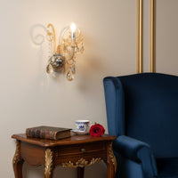 Wall light with champagne glass frame and crystal droplets styled on a soft wall background for warm elegant home lighting.