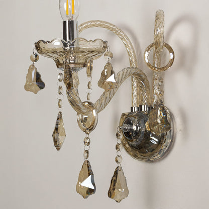 Closeup of champagne wall light showing twisted glass arms and crystal drops for refined elegant interior lighting.
