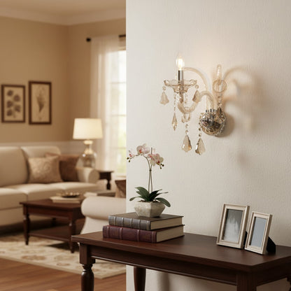 Wall light with champagne glass frame and crystal droplets styled on a soft wall background for elegant warm home lighting.