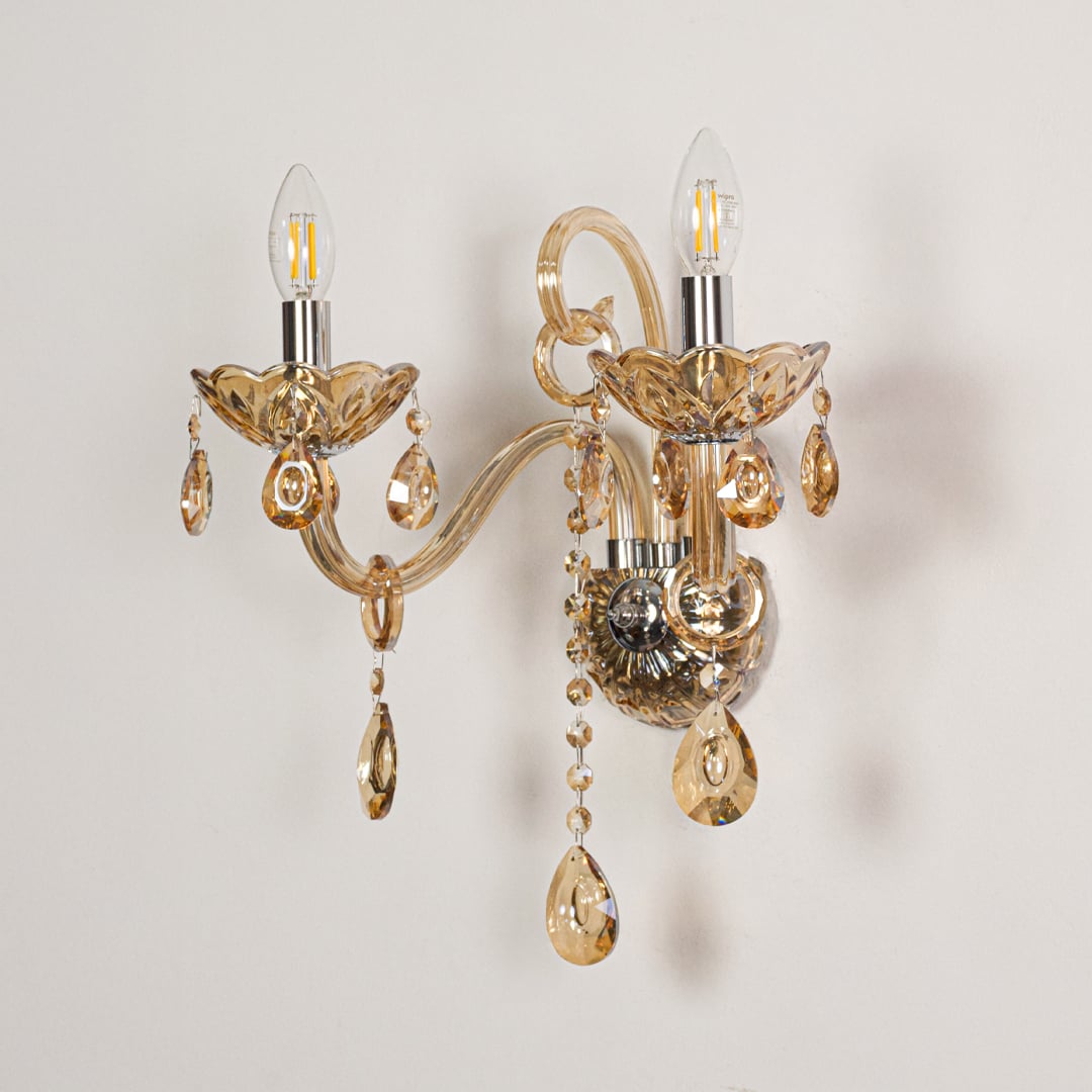 Golden crystal dual arm wall light with decorative beads shown on white background ideal for classic home interiors.