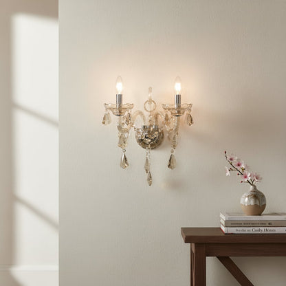 Wall light with champagne glass frame and crystal droplets styled on a soft wall background for elegant warm home lighting.