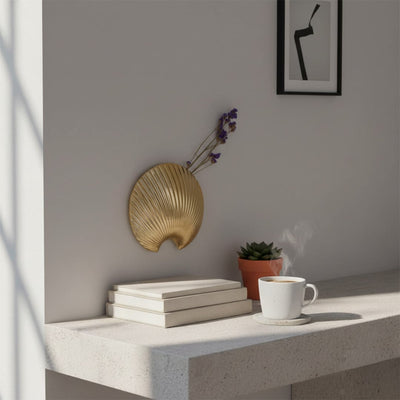 Gold shell shaped wall decor displayed in a clean modern setting adding a bold metallic accent to contemporary interiors.