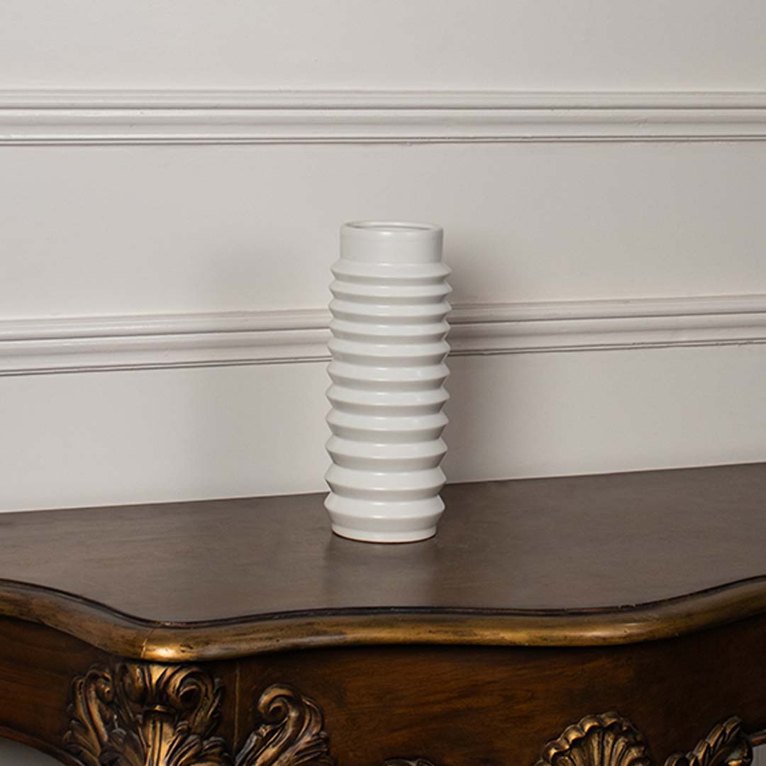 Glossy ribbed ceramic vase in white finish displayed against plain white background for clean product view.
