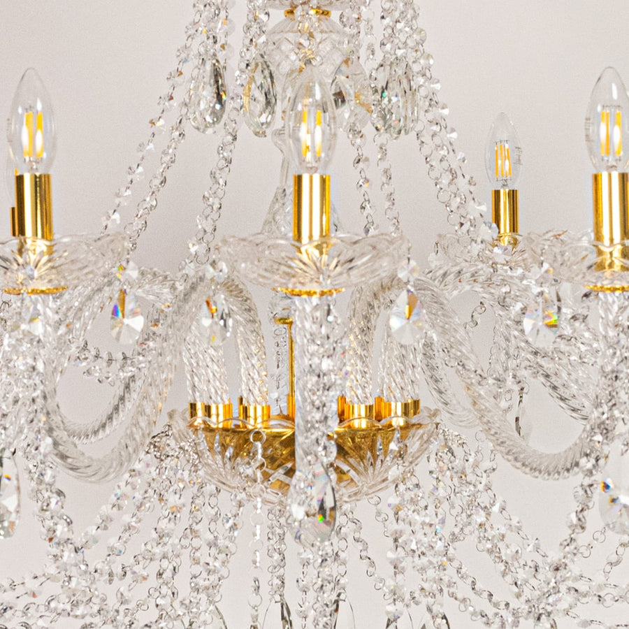Closeup of large gold crystal chandelier with layered crystal chains and droplets perfect for luxury ceiling decor.