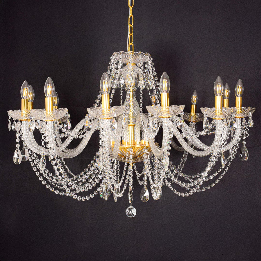 Large gold crystal chandelier shown on black background highlighting premium crystal detailing for elegant interiors.