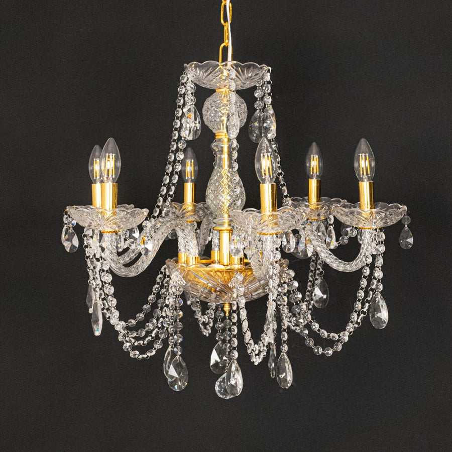 Gold metal crystal chandelier shown on black background highlighting premium crystal detailing for elegant interiors.
