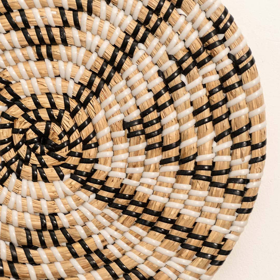 Detailed closeup of handcrafted black natural seagrass wall basket with woven geometric chevron pattern for artisan decor.