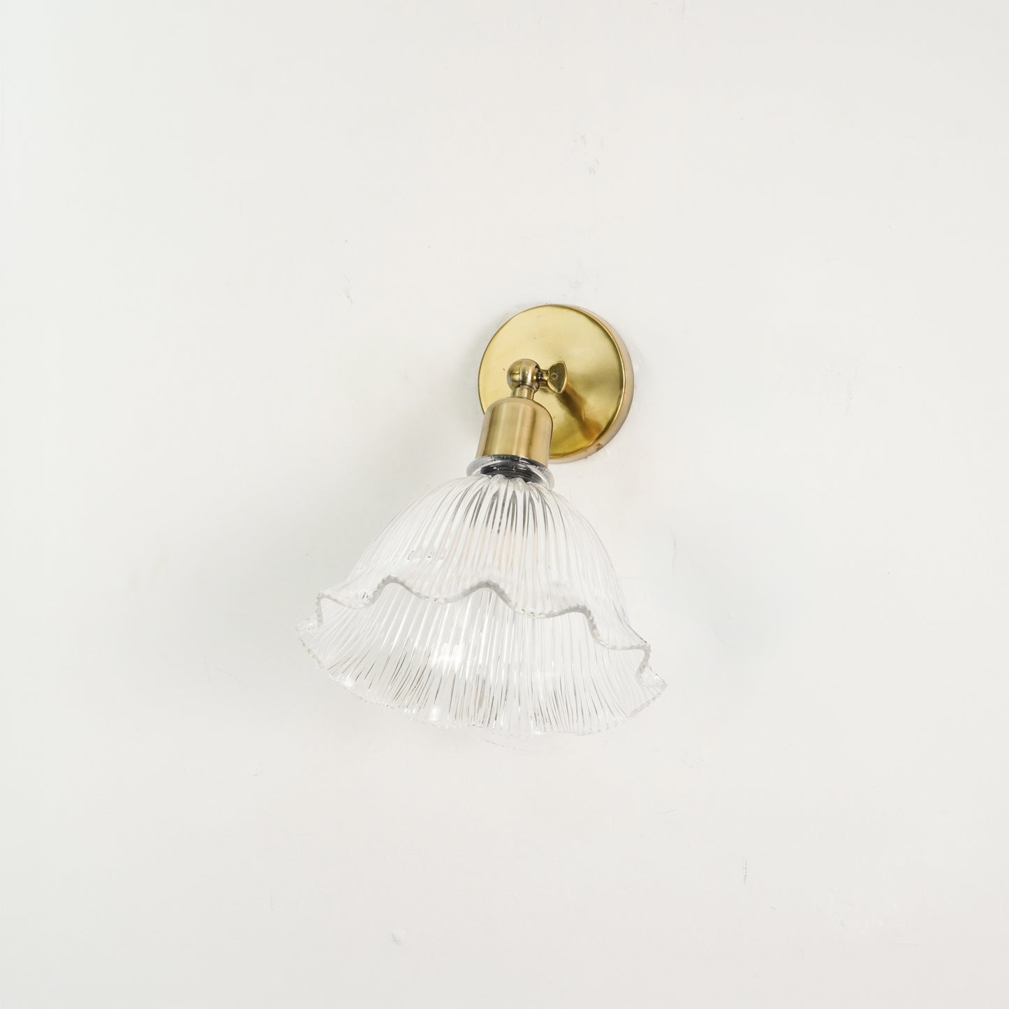 White background image of elegant ivory half shade wall sconce with antique brass finish for modern home lighting design.