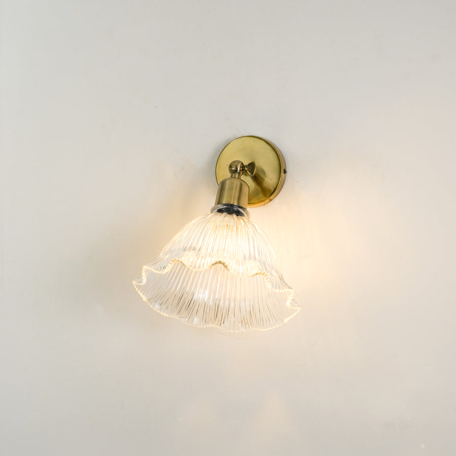 White background image of elegant ivory half shade wall sconce with antique brass finish for modern home interior lighting.