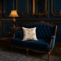 Soft cotton cushion cover with beige and brown floral embroidery displayed on a navy sofa creating a refined elegant décor accent with a breathable gentle and skin friendly fabric feel.