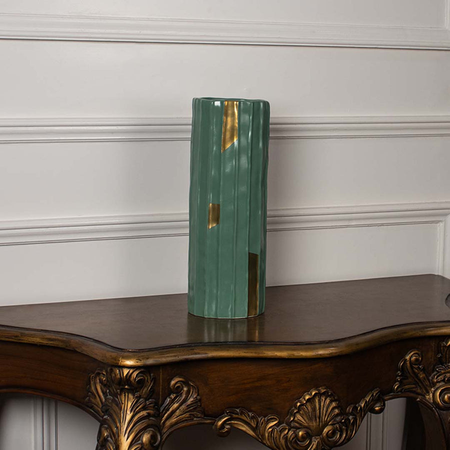 Tall green ribbed ceramic vase with subtle gold detailing shown on a plain white background perfect for minimal elegant interior styling.