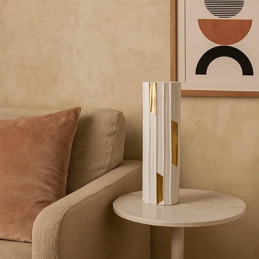Tall modern vase with a white ribbed body and metallic gold accents styled in a minimal setting to highlight its elegant shape and refined contemporary look.