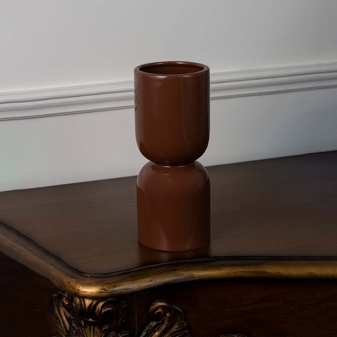 Brown ceramic vase with glossy finish placed on a white background for modern home and office decor.