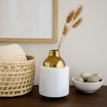 White ceramic decor vase with gold metal neck styled on wooden console table adding elegant modern accent to living room home decor.
