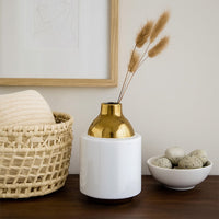 White ceramic decor vase with gold metal neck styled on wooden console table adding elegant modern accent to living room home decor.
