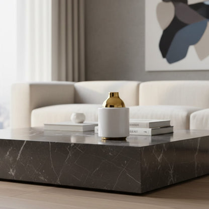 White ceramic vase set with gold and chrome tops styled on a wooden table creating a warm minimal decor look with soft dried stems adding natural elegance.