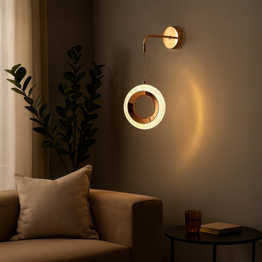 Gold metal wall mounted ring pendant light glowing warmly beside sofa adding elegant ambient lighting to modern living room interior decor.