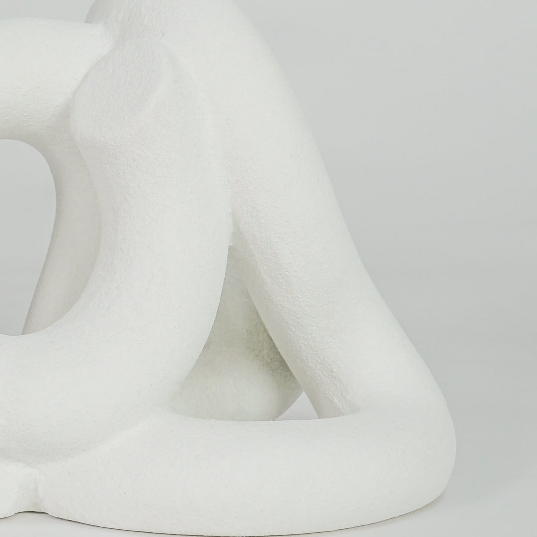 Closeup image of white ceramic abstract loop sculpture for modern tabletop decor styling with elegant matte finish.